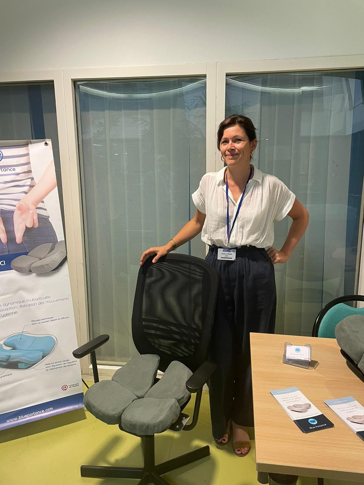 Dr. Amélie Lévesque steht neben einem Sessel mit Aporia-Sitzfläche am Stand von Blue Portance.